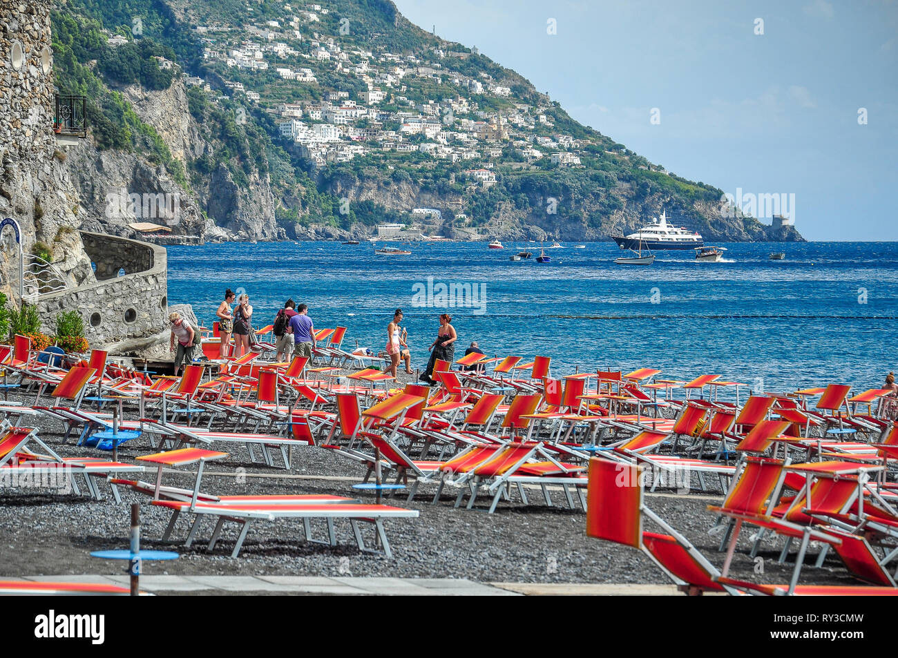 POSITANO, Italien - 12 SEPTEMBER 2013: Touristen, Sonnenschirme und Liegen am Strand Stockfoto