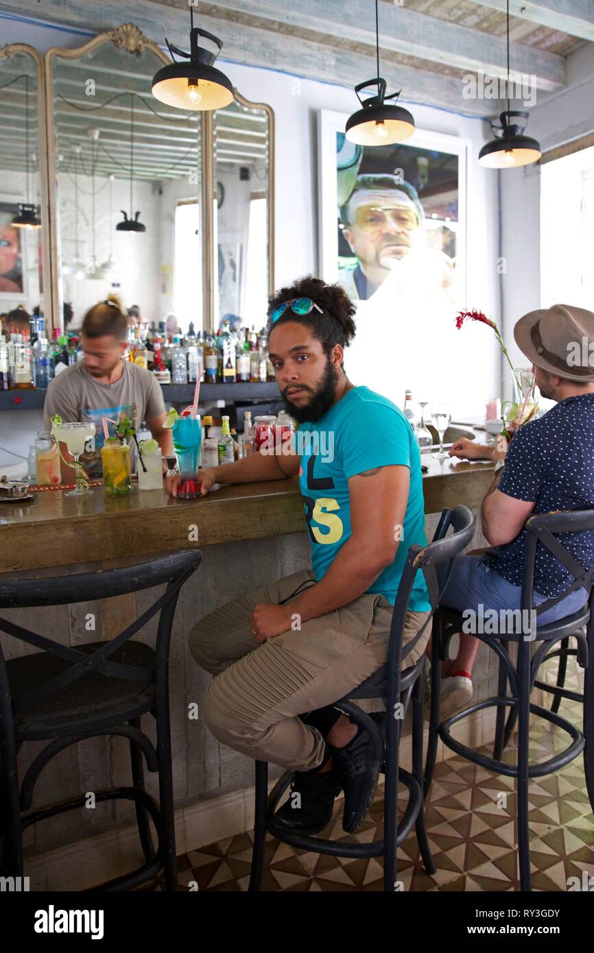 Kuba, Havanna, alte Habana, als Weltkulturerbe von der UNESCO, Orlando Abreu, Inhaber der trendigen Bar Restaurant El del Frente an der Theke sitzend mit einem Cocktail Stockfoto