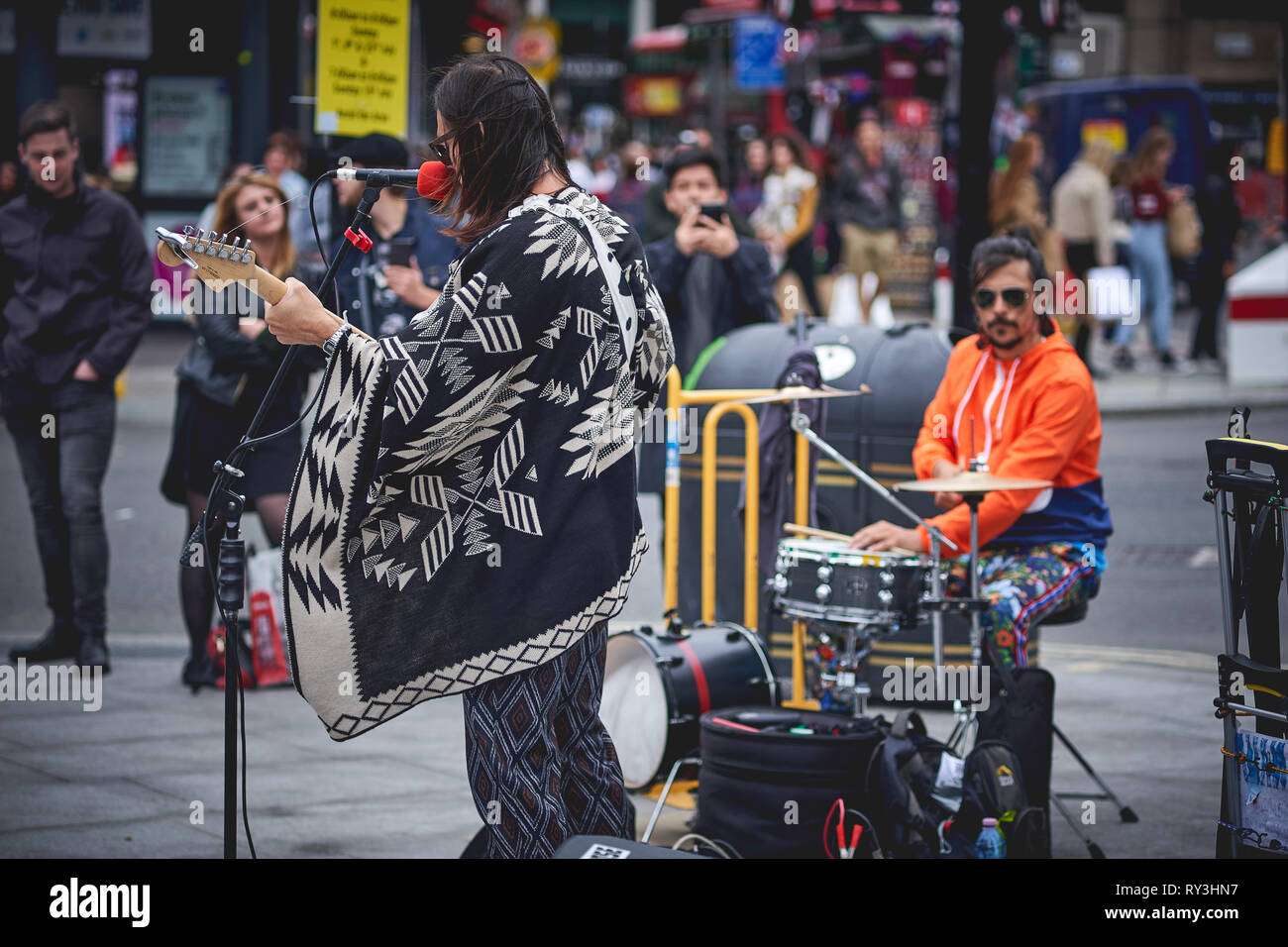 London, UK - August, 2018. Eine strasse Rock Musiker Durchführung außerhalb der Tottenham Court Road U-Bahnstation in einem überfüllten Oxford Street. Stockfoto