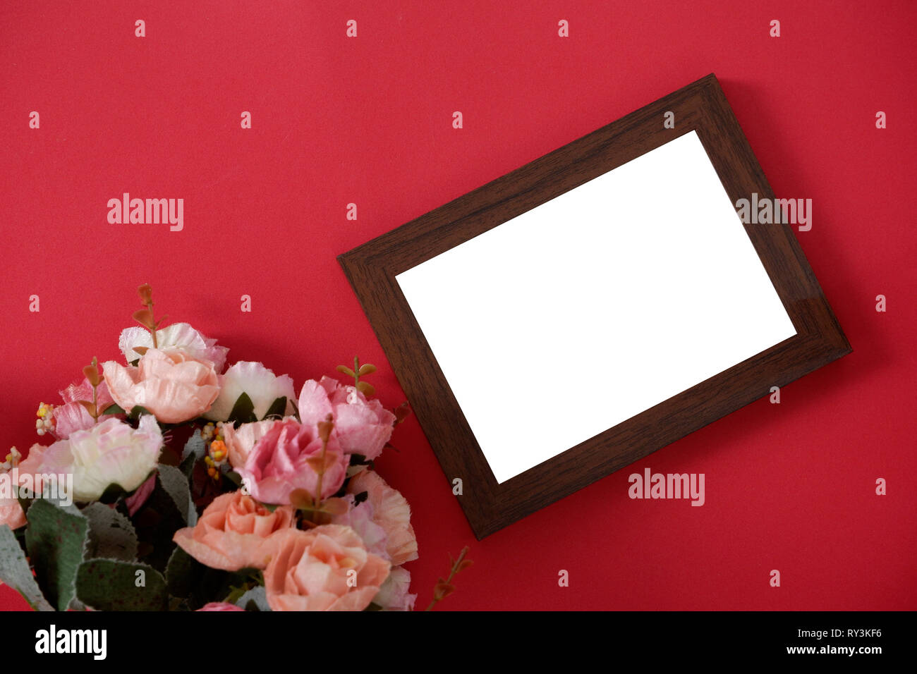 Mock-up Holz Bilderrahmen mit Platz für Bild oder Text auf rotem Hintergrund und Blume Stockfoto