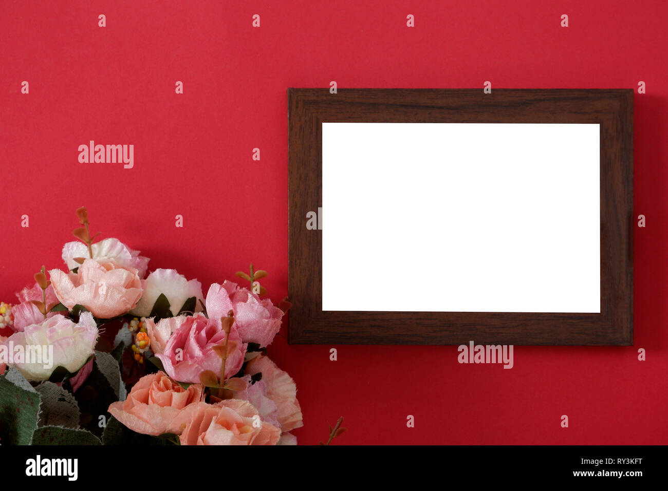 Mock-up Holz Bilderrahmen mit Platz für Bild oder Text auf rotem Hintergrund und Blume Stockfoto