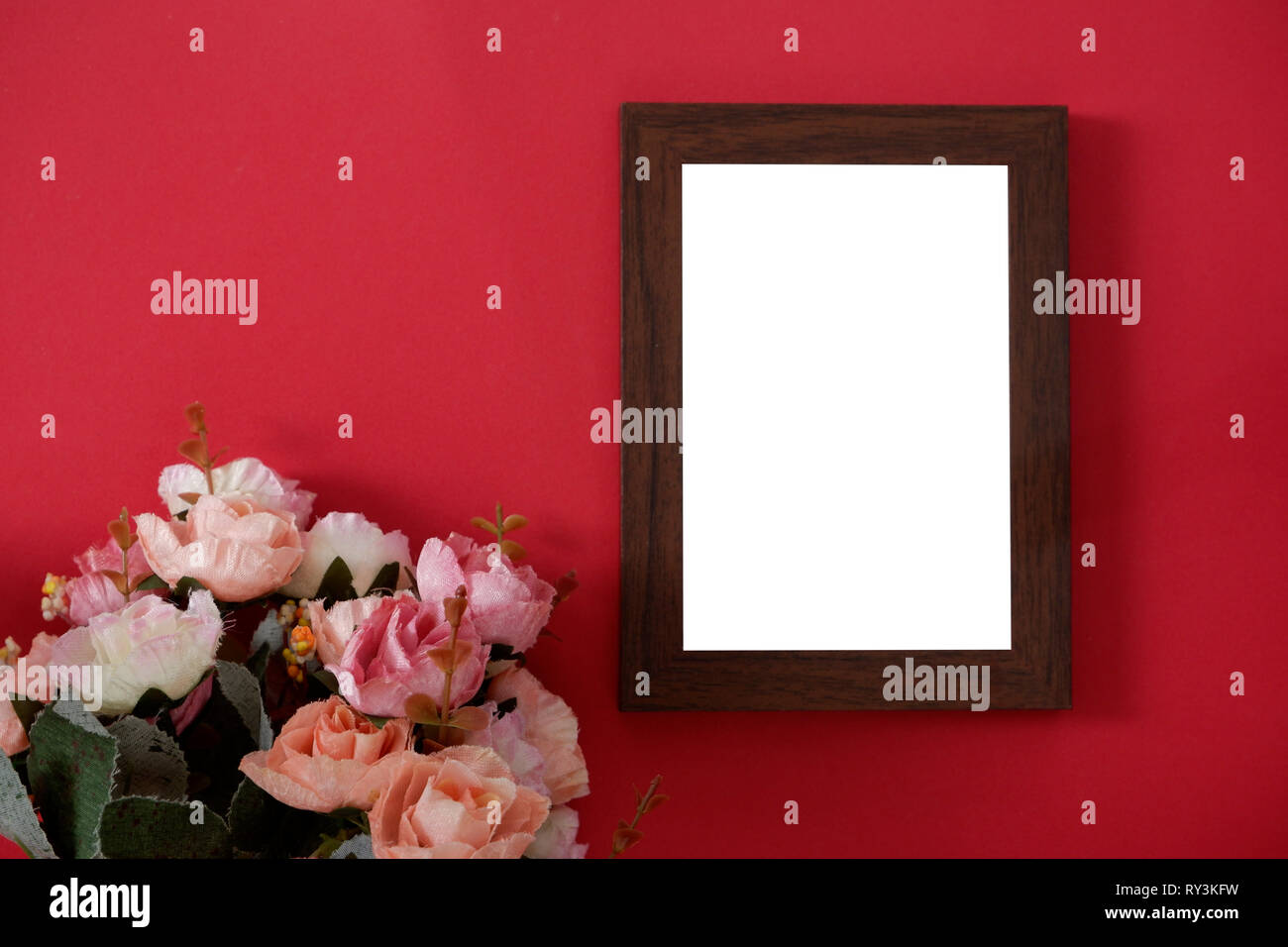 Mock-up Holz Bilderrahmen mit Platz für Bild oder Text auf rotem Hintergrund und Blume Stockfoto