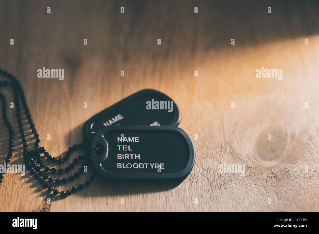 Soldat Variable oder Dog Tag auf braune Holztisch und Sonnenlicht gelegt. Stockfoto