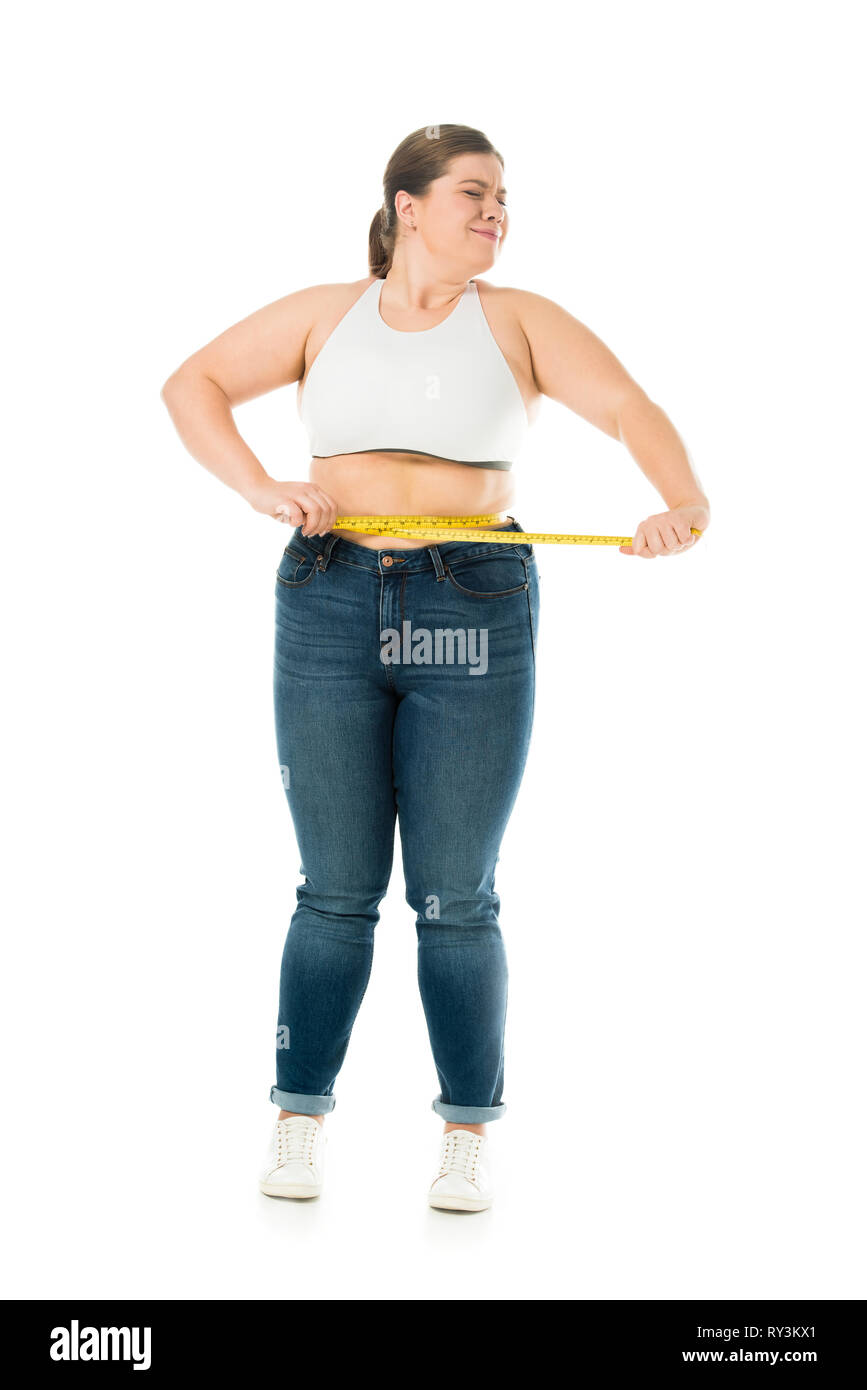 Traurig übergewichtige Frau mit geschlossenen Augen messen Taille isoliert auf weißem Stockfoto