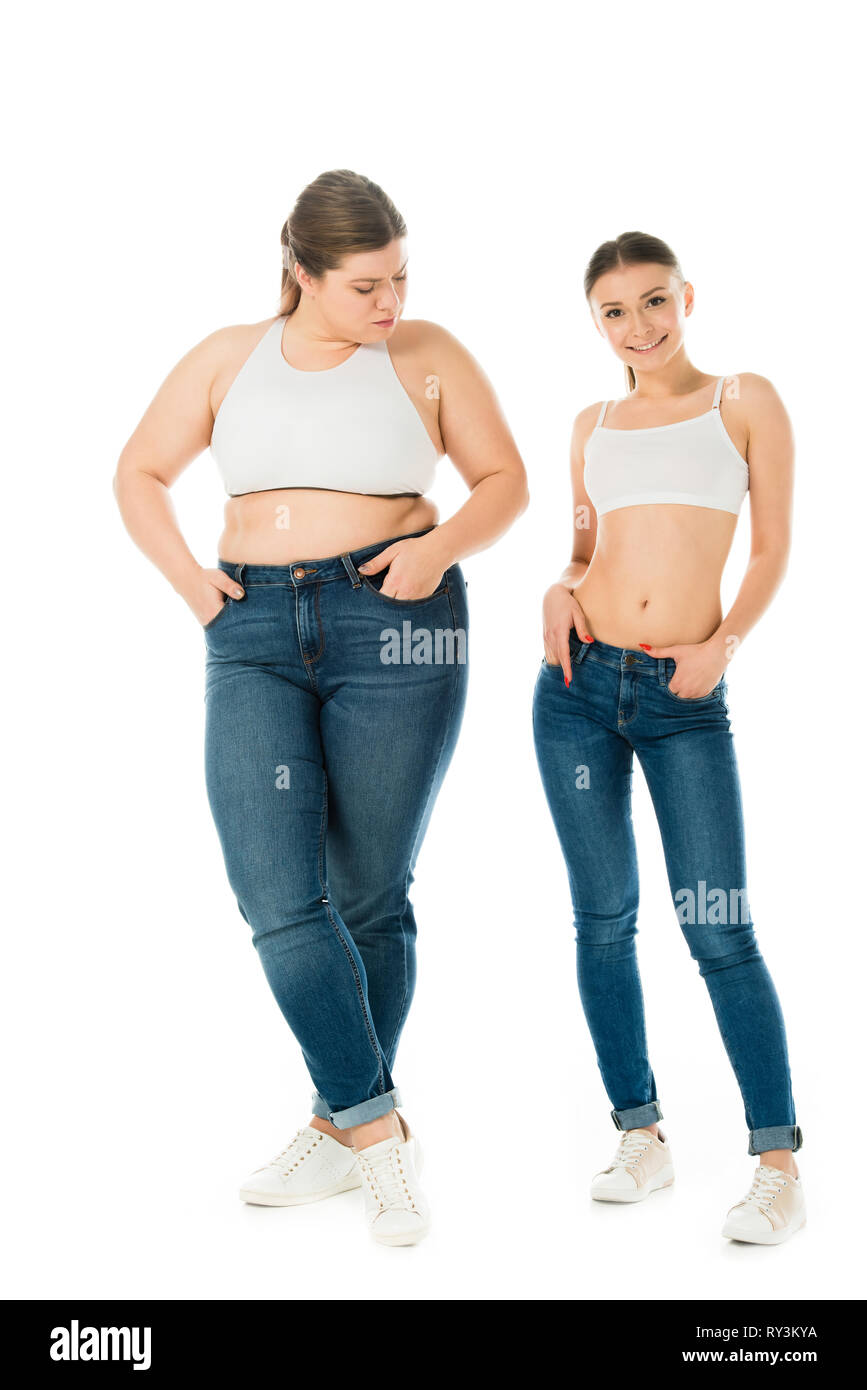 Traurig übergewichtige Frau eifersüchtig auf lächelnde schlanke Schöne Frau isoliert auf weißem suchen Stockfoto