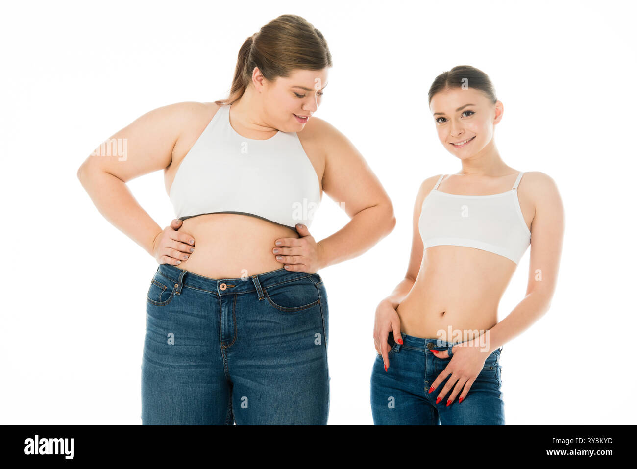 Schlank und übergewichtige Frauen in Jeans zusammen auf Weiß, Körper Positivität Konzept isoliert Posing Stockfoto