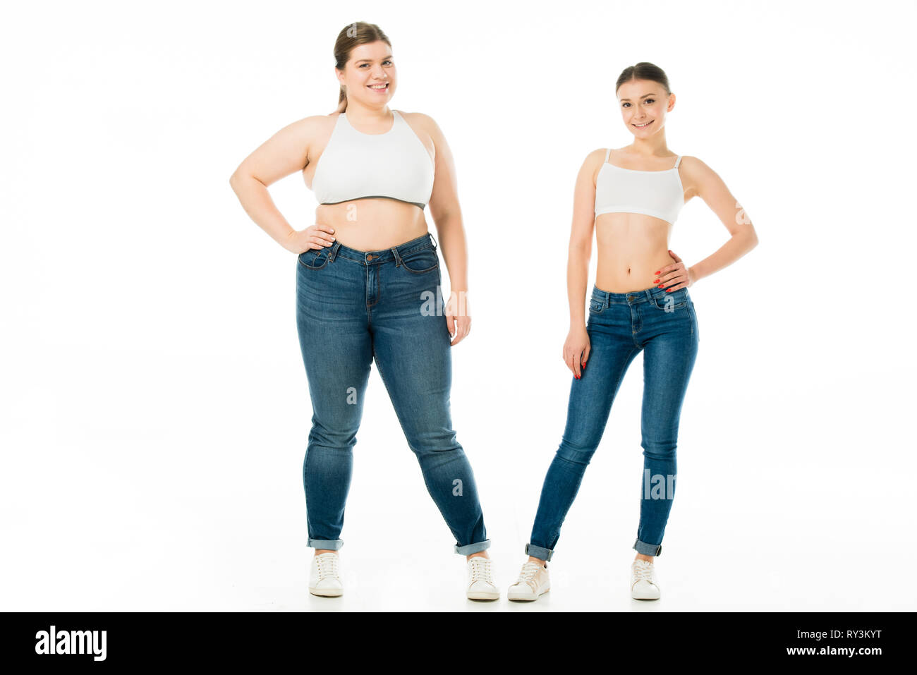Gerne schlank und übergewichtige Frauen in Jeans zusammen auf Weiß, Körper Positivität Konzept isoliert Posing Stockfoto