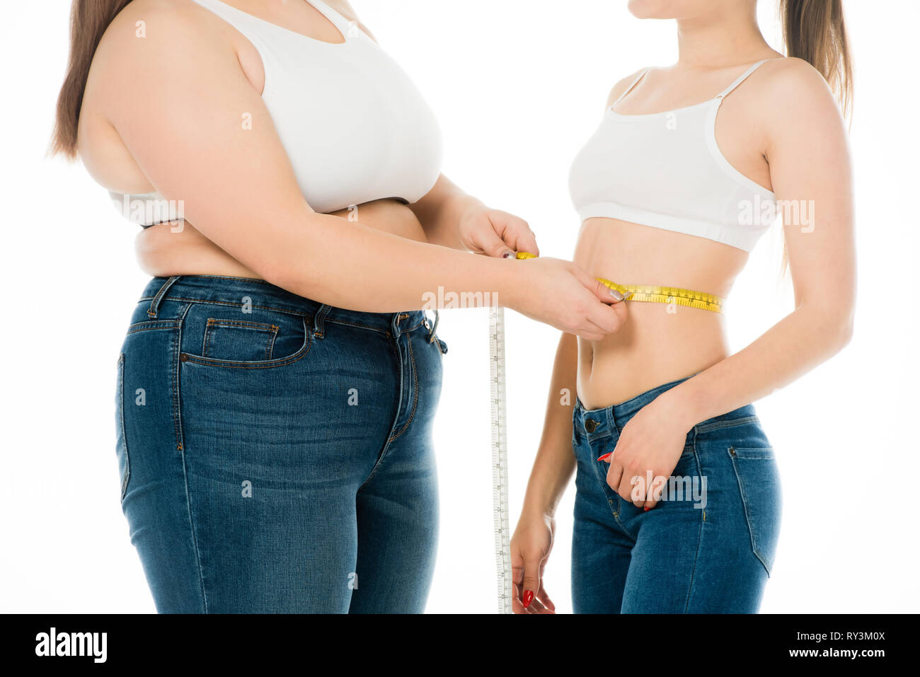 7/8-Ansicht von übergewichtigen Frau messen Taille schlanke Frau isoliert auf weiss Stockfoto