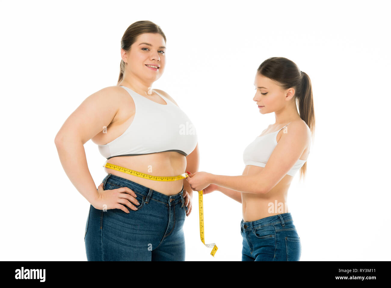 Schlanke Frau messen Taille von Happy übergewichtige Frau auf Weiß, Körper Positivität Konzept isoliert Stockfoto