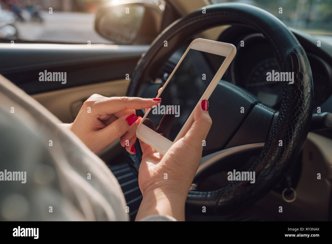 Mockup Bild der Frau hand mit Mobile Smartphone mit leerer Bildschirm während der Fahrt Auto und Haus verlassen. freistellungspfaden. Stockfoto