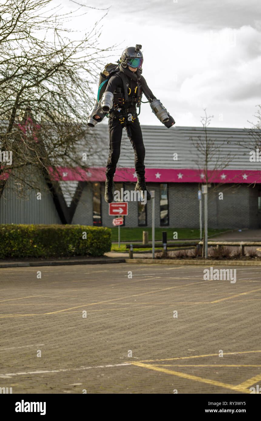 BASINGSTOKE, UK - 11. MÄRZ 2019: Gymnast Ryan Hopgood demonstriert eine Schwerkraft Branchen Jet Pack von Fliegen über den Parkplatz am Basingstoke Freizeitaktivitäten Stockfoto