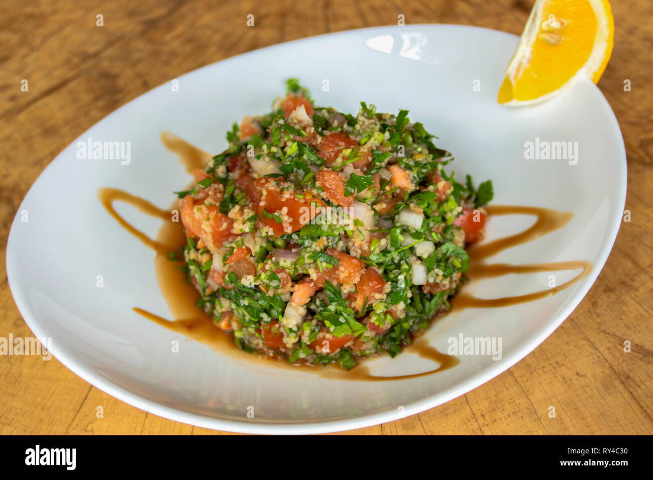 Salat Tabule. Mit Petersilie, Tomaten, roten Zwiebeln, manna Kruppe, Granatapfelsaft und frisch gepresste Zitrone. Stockfoto