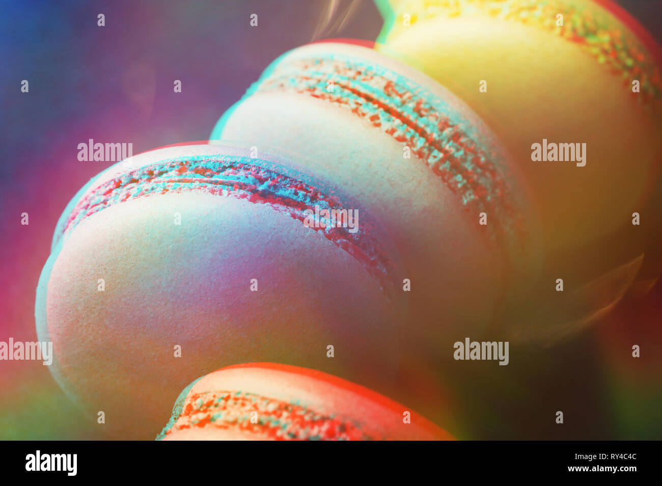 Bunte macarons auf dunkelblauem Hintergrund mit 3D-Effekt. Ansicht von oben, aus der Nähe. Stockfoto