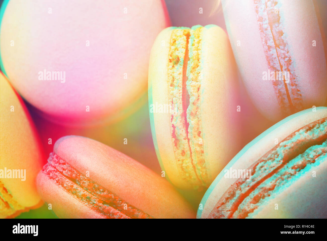 Bunte macarons auf dunkelblauem Hintergrund. Ansicht von oben, Nahaufnahme, getönt mit trendigen 3D-Effekt. Stockfoto