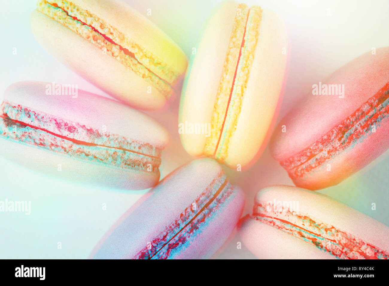 Reihe der bunte Macarons auf Türkisfarbenem Hintergrund. Ansicht von oben, Nahaufnahme, 3D-Effekt, getönten Bild. Stockfoto