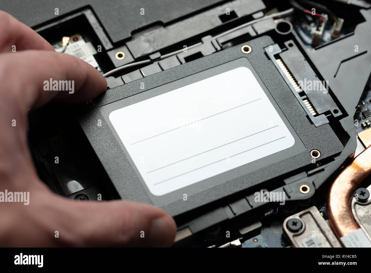 Installation neuer Solid-State-Drive, Laptop-PC. SATA-und Stromanschluss in der Nähe. Upgrade laptop Hardware. Stockfoto