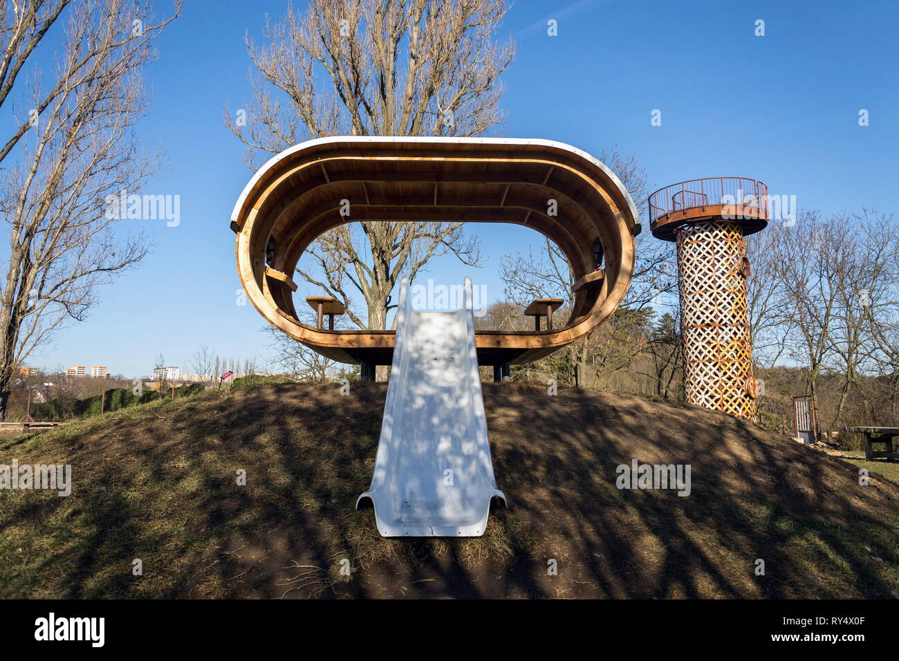 Schöne hölzerne Spielhaus für Kinder mit Rutsche an einem sonnigen Tag Stockfoto