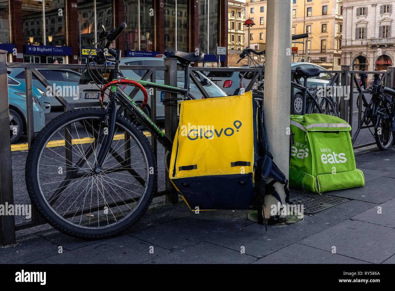 Essen Lieferung Fahrrad Service. Glovo, Uber isst Rucksacktaschen, Lieferfahrräder vor dem Bahnhof Termini, Rom, Italien, Europa, EU geparkt Stockfoto