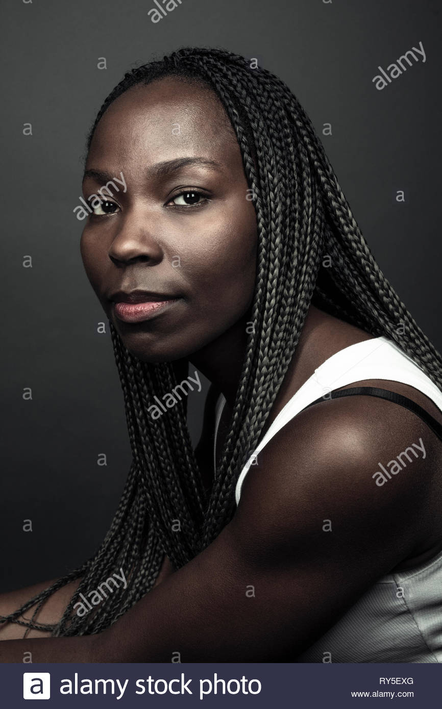 Portrait zuversichtlich, schöne junge afrikanische amerikanische Frau mit langen schwarzen Zöpfen Stockfoto
