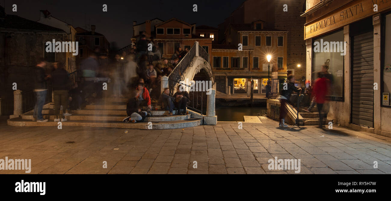 Ein Schuß von Menschen hängen und Spaß auf einer Brücke in Venedig, Italien Stockfoto