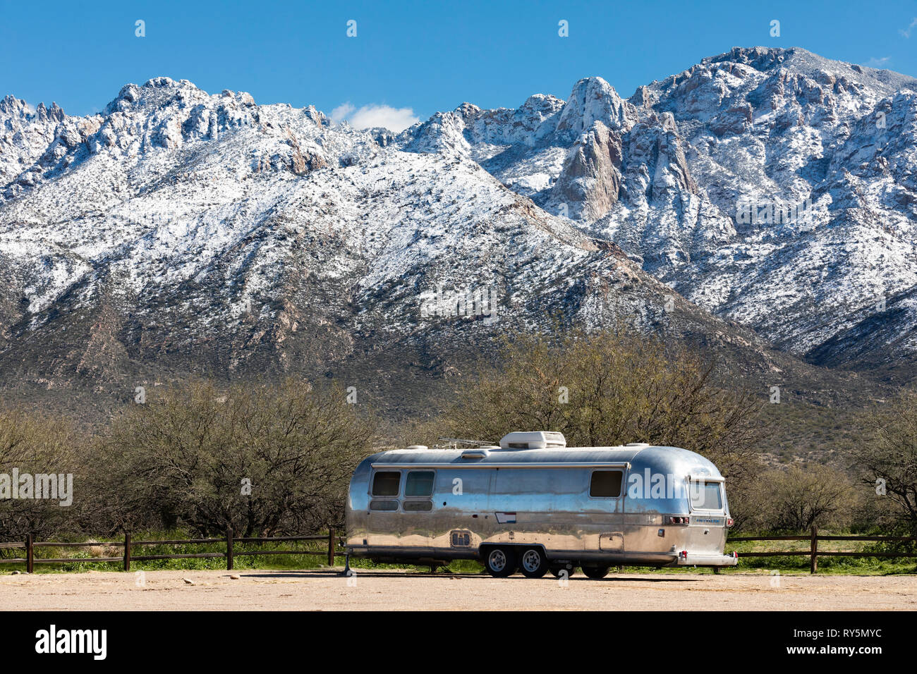 Airstream Anhänger mit schneebedeckten Bergen im Hintergrund geparkt, Catalina State Park, Tucson, Arizona Stockfoto