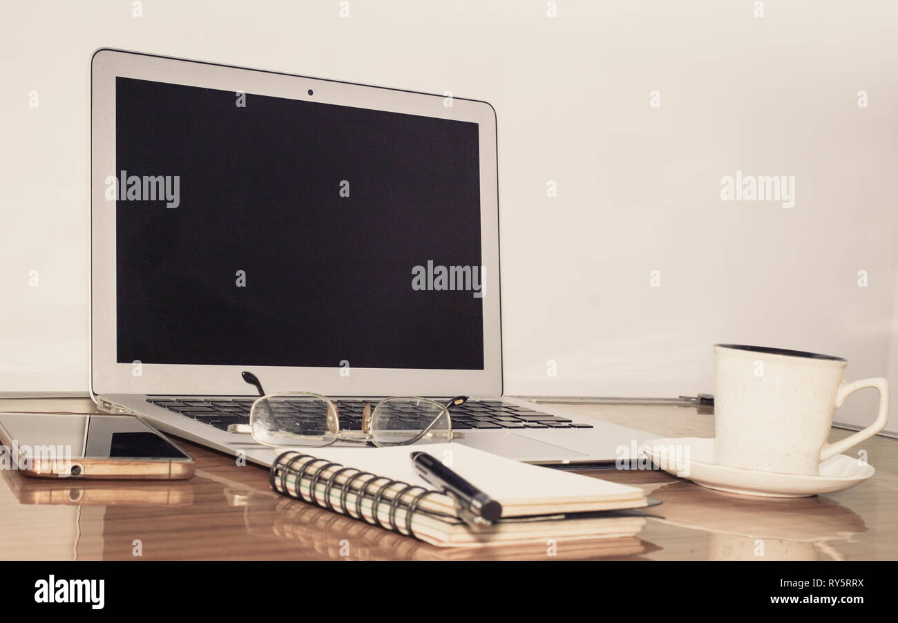 Schreibtisch mit Notebook, Handy, Brille, Stift und eine Tasse Kaffee. Ansicht von oben mit der Kopie. Business still life Konzept mit Office Material o Stockfoto