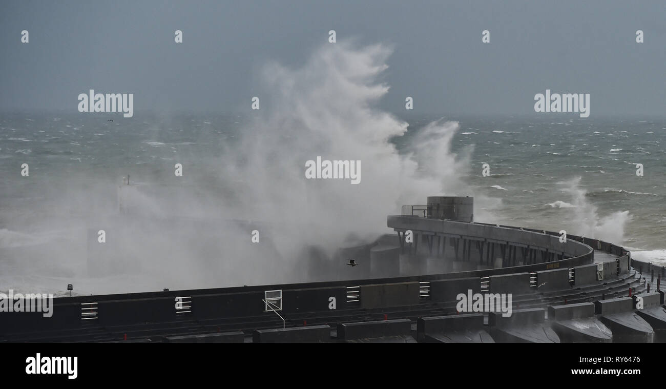 Brighton, UK. 12 Mär, 2019. Wellen über Brighton Marina westliche Mauer heute morgen als Sturm Gareth startet Großbritannien und Irland zu Teig mit Winde erwartet über 70 mph in einigen Teilen: Simon Dack/Alamy Leben Nachrichten erreichen Stockfoto