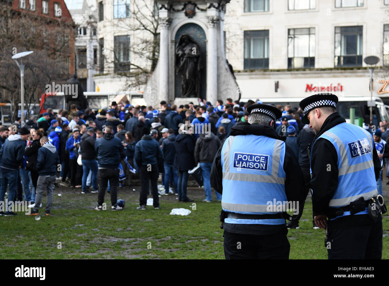 12. März 2019, Großbritannien, Manchester: Fußball: Champions League, Manchester City - FC Schalke 04, K.o.-Runde, Achtelfinale, Rückspiel bei Etihad Stadium. Polizisten sind gerade Fans von Schalke am Picadilly Gardens Square. Foto: Ina Faßbender/dpa Stockfoto