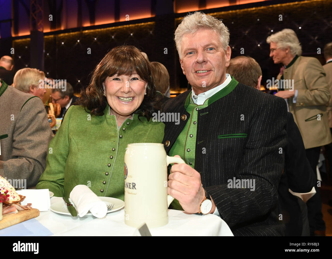 12. März 2019, Bayern, München: Dieter Reiter (SPD), Oberbürgermeister von München, und seine Frau Petra, während eine starke Bier Tippen auf dem Nockherberg aufgezeichnet. Die traditionelle Hohn, der 'derblecken' von Politikern am Münchner Nockherberg, eröffnet traditionell Das starke Bier Jahreszeit in Bayern. Foto: Tobias Hase/dpa Stockfoto