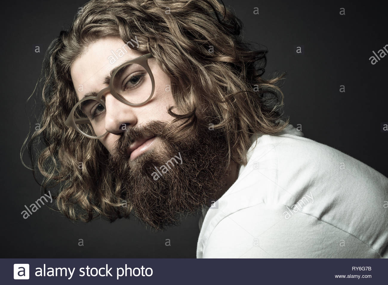 Portrait zuversichtlich gutaussehenden jungen Mann mit dem lockigen langen Haare und Bart Stockfoto