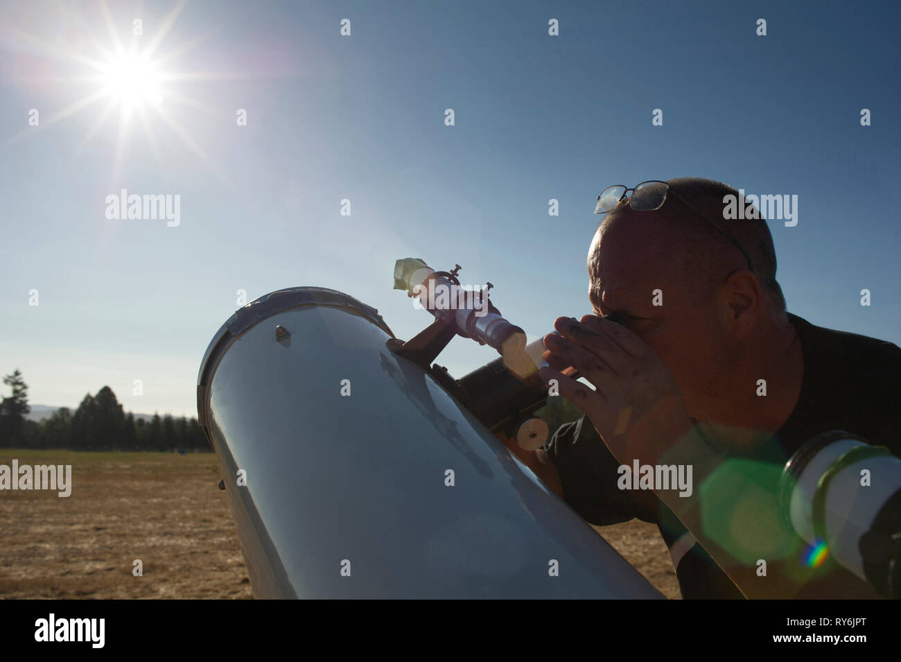 Astronomen auf der Suche helle Sonne durch Teleskop gegen den klaren Himmel während der sonnigen Tag Stockfoto
