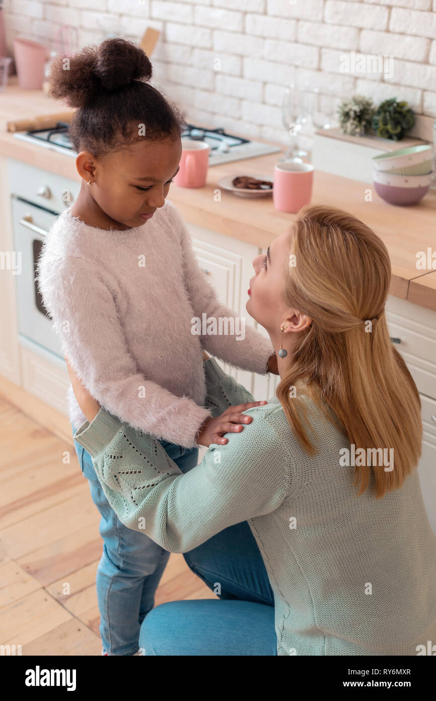 Cute curly Tochter umarmte ihre fürsorgliche liebevolle Mutter Stockfoto