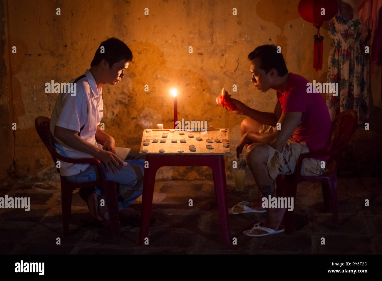 Männer spielen Chinese Checkers Spiel bei Kerzenlicht in Hoi An, Vietnam Stockfoto