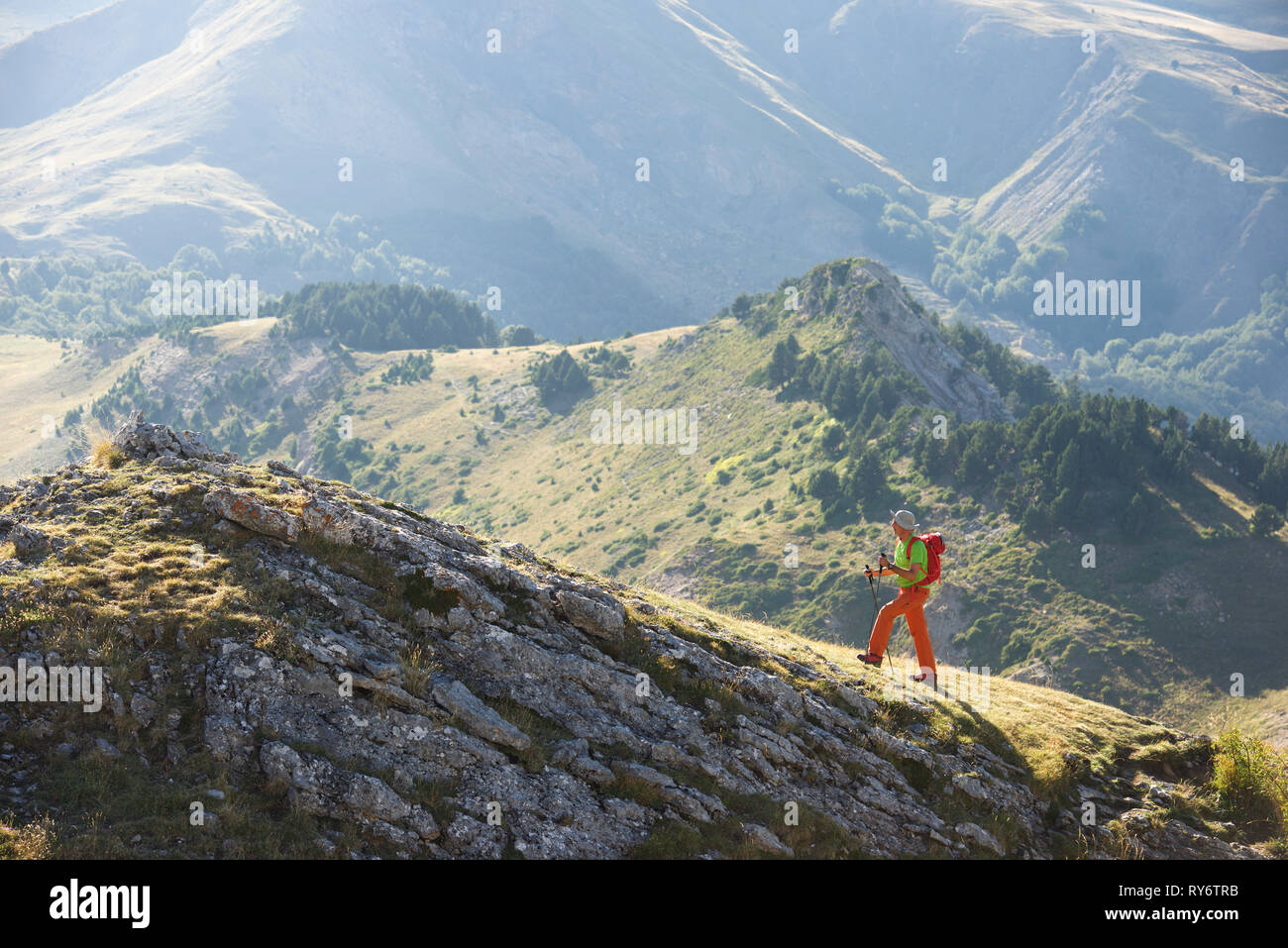 Seitenansicht des Backpacker mit Wanderstöcken Klettern am Berg Stockfoto