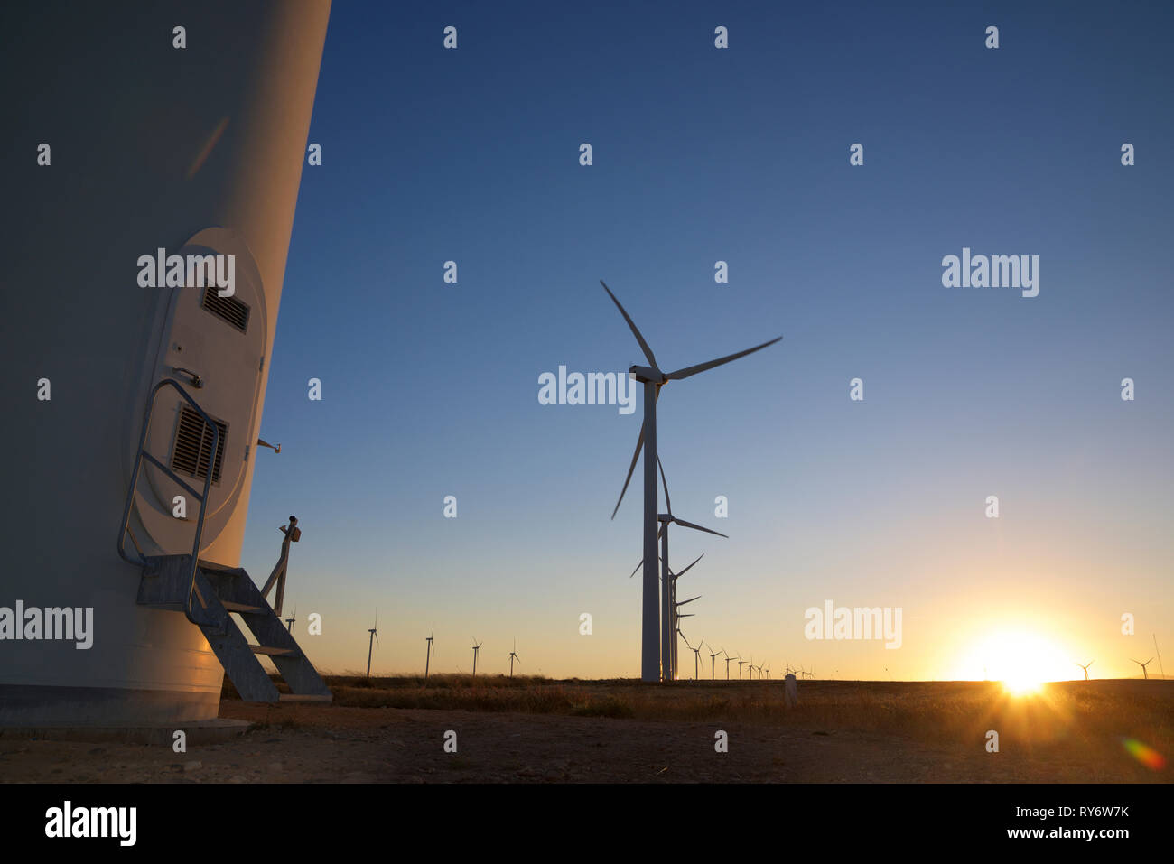 Oberfläche Bild von Silhouette Windmühlen auf Landschaft gegen den klaren blauen Himmel bei Sonnenuntergang Stockfoto