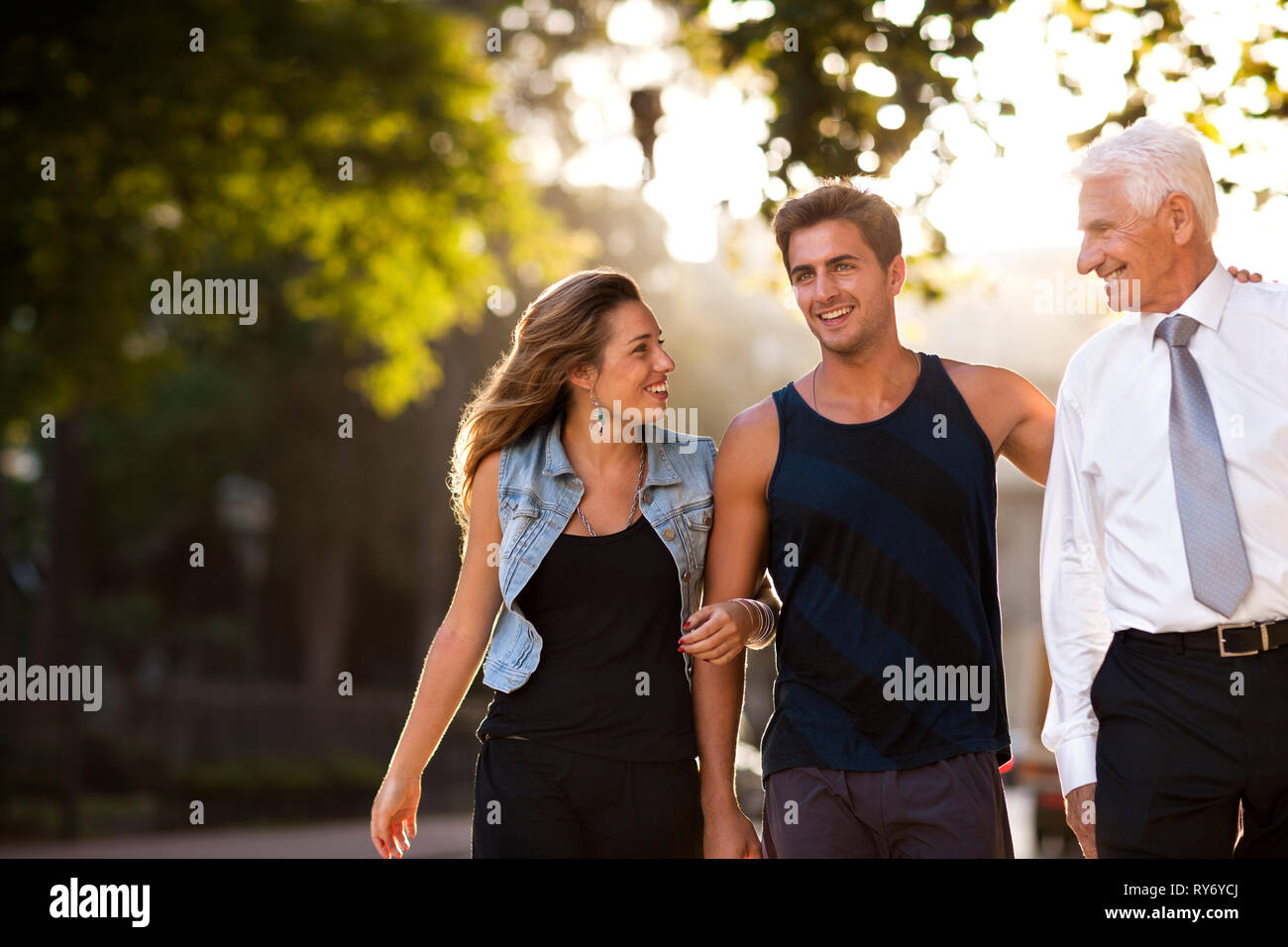 Porträt der Menschen auf dem Weg nach unten Stadt Straße mit seinem erwachsenen Sohn und seine Freundin. Stockfoto