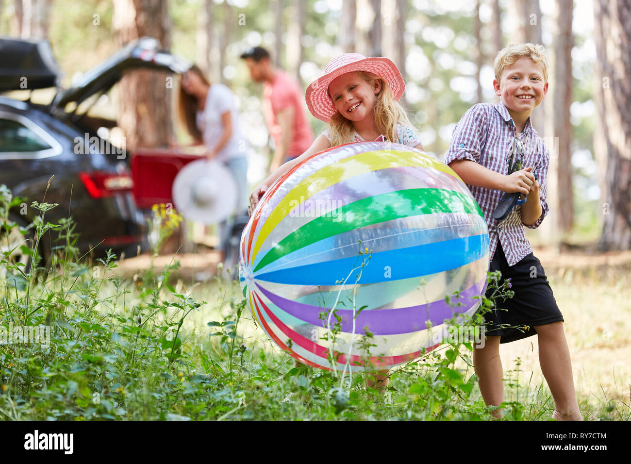 Geschwister Kinder spielen mit einem bunten Ball in den Sommerferien Stockfoto