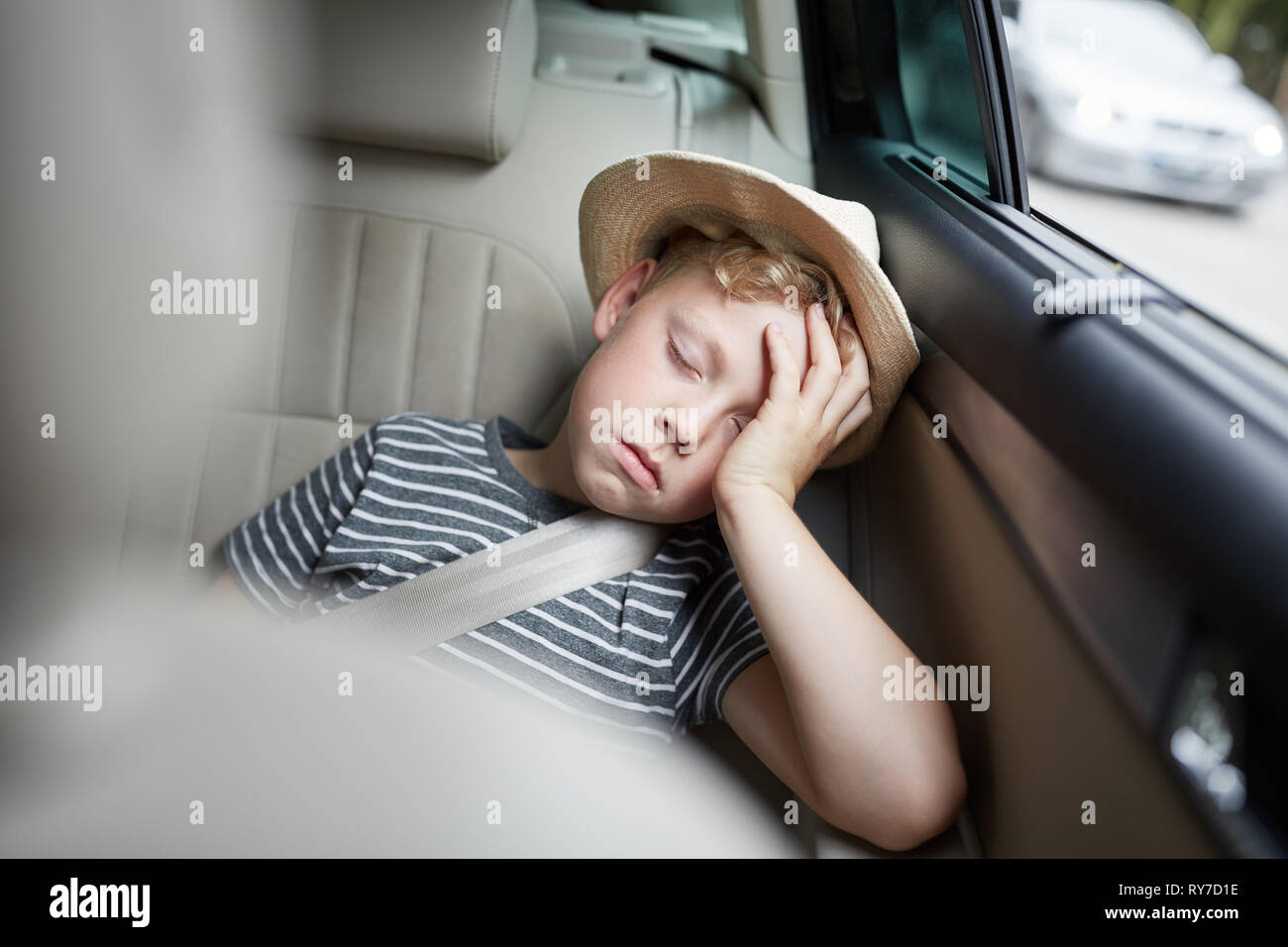 Müde Geschwister schlafen auf dem Rücksitz, während sie im Auto unterwegs  sind Stockfotografie - Alamy