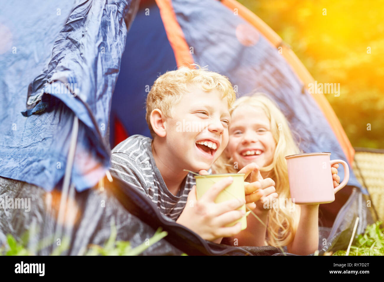 Zwei glückliche Kinder werden zusammen campen im Zelt im Sommer Stockfoto