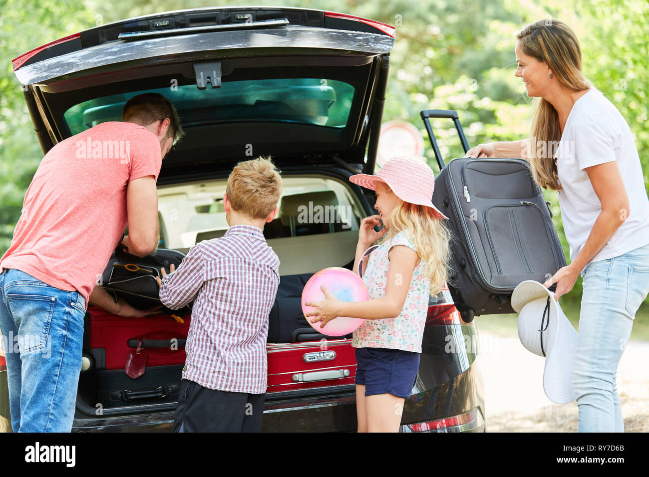 Familie mit Kindern zusammen packen Koffer in das Auto, bevor Sie auf Geschäftsreise Stockfoto