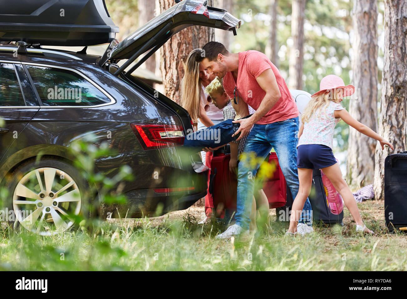 Familie im Auto laden aus dem Stamm mit Gepäck vor der Reise Stockfoto