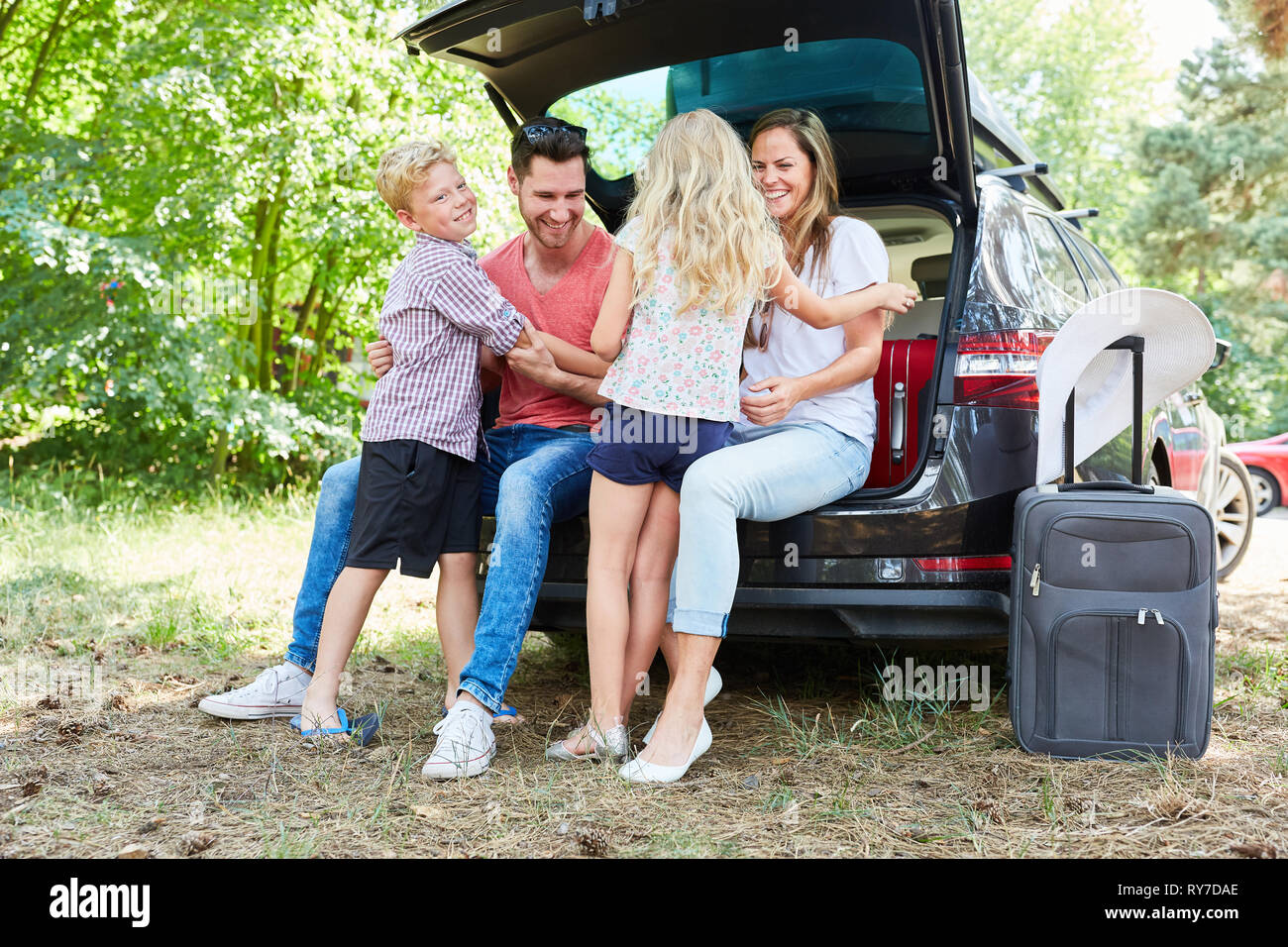 Familie mit Kindern im Auto nimmt einen Rest oder freut sich auf die Sommerferien Stockfoto