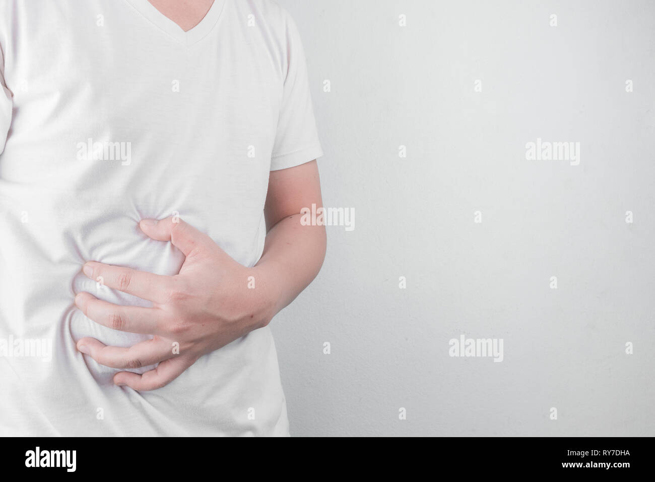 Asiatische junge Männer leiden unter Magengeschwüren. Gastritis durch die Infektion mit H. pylori-Bakterien im Gesundheitswesen und Gesundheit Problem Konzept verursacht Stockfoto