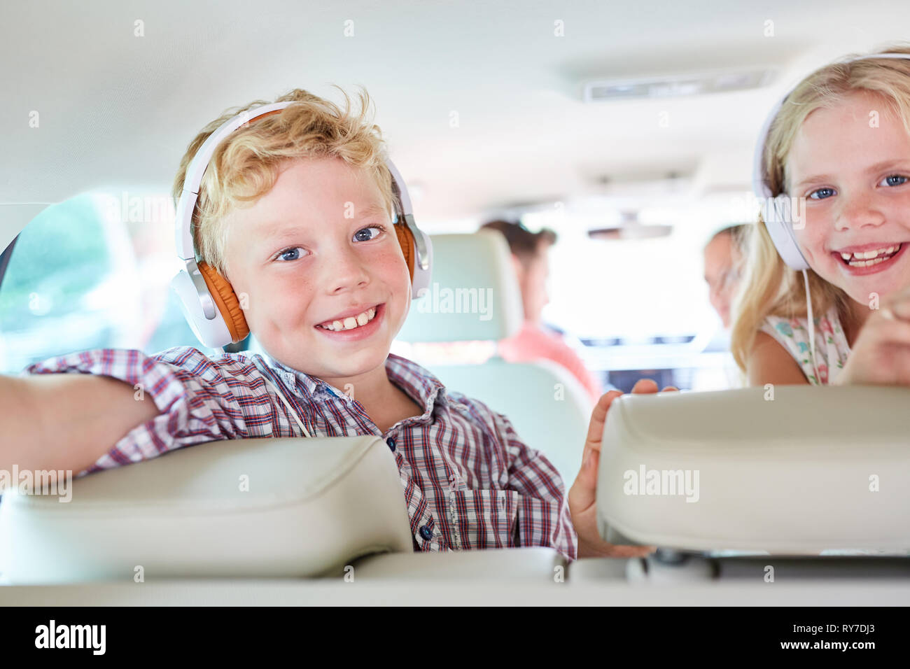 Geschwister Kinder Musik hören über Kopfhörer oder ein Hörbuch im Auto Stockfoto