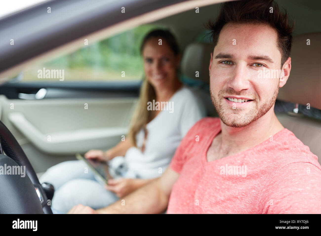 Junge Menschen als zufriedene Autofahrer auf der Fahrt im Auto oder Mietwagen Stockfoto