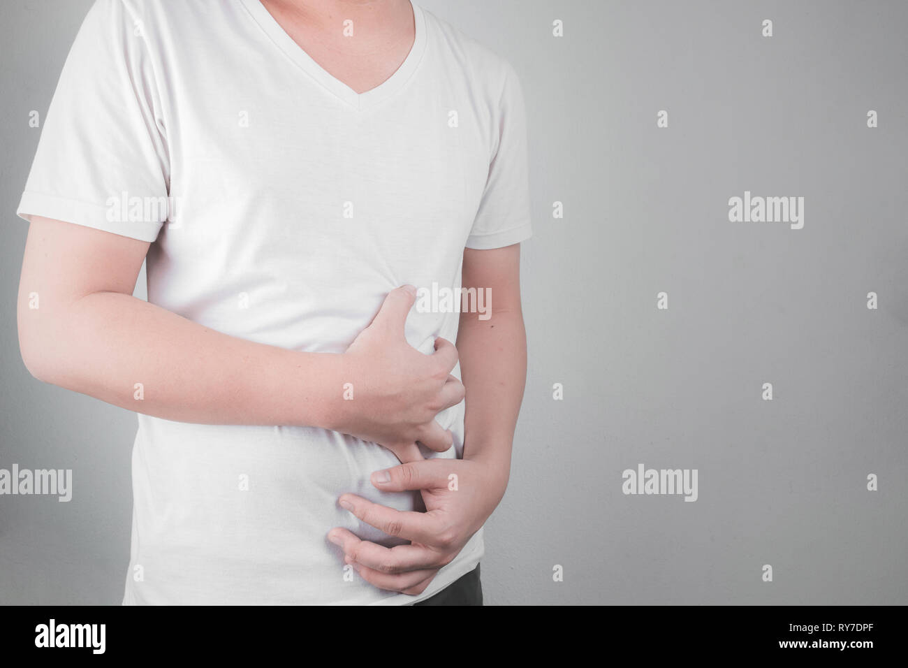 Asiatische junge Männer leiden unter Magengeschwüren. Gastritis durch die Infektion mit H. pylori-Bakterien im Gesundheitswesen und Gesundheit Problem Konzept verursacht Stockfoto