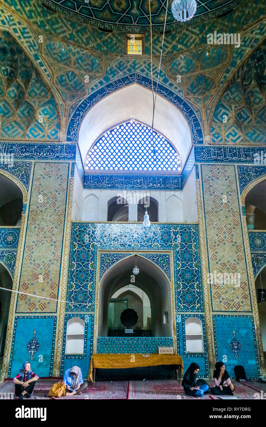 Yazd Masjid-e Jameh Moschee Innenraum mit blauen Kacheln Ornament und sitzen Leute Stockfoto