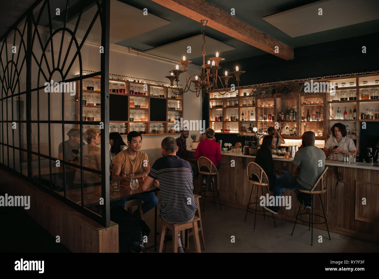 Diverse Leute genießen Getränke an der Bar am Abend Stockfoto