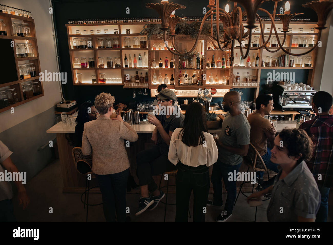 Unterschiedliche Menschen, um einen Drink in einem Pub am Abend Stockfoto