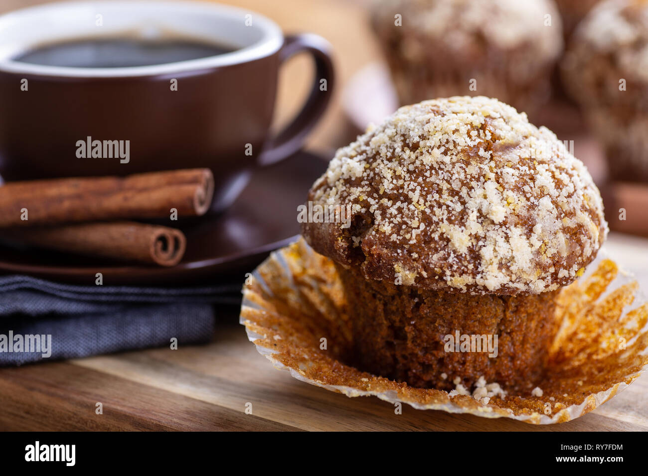 Nahaufnahme eines pumpkin Muffin mit einer Tasse Kaffee und Muffins im Hintergrund Stockfoto